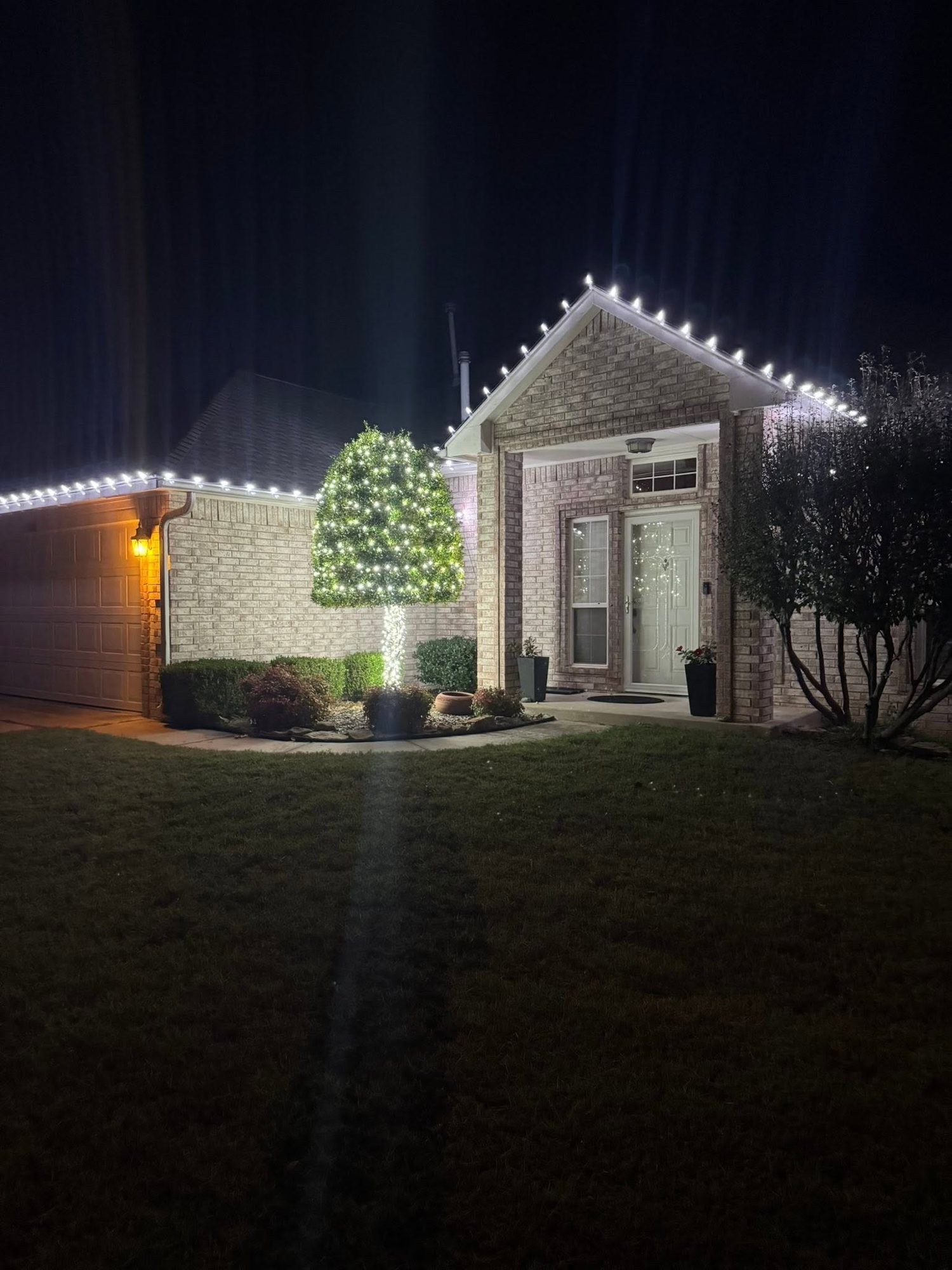 Warm white roofline with a wrapped tree