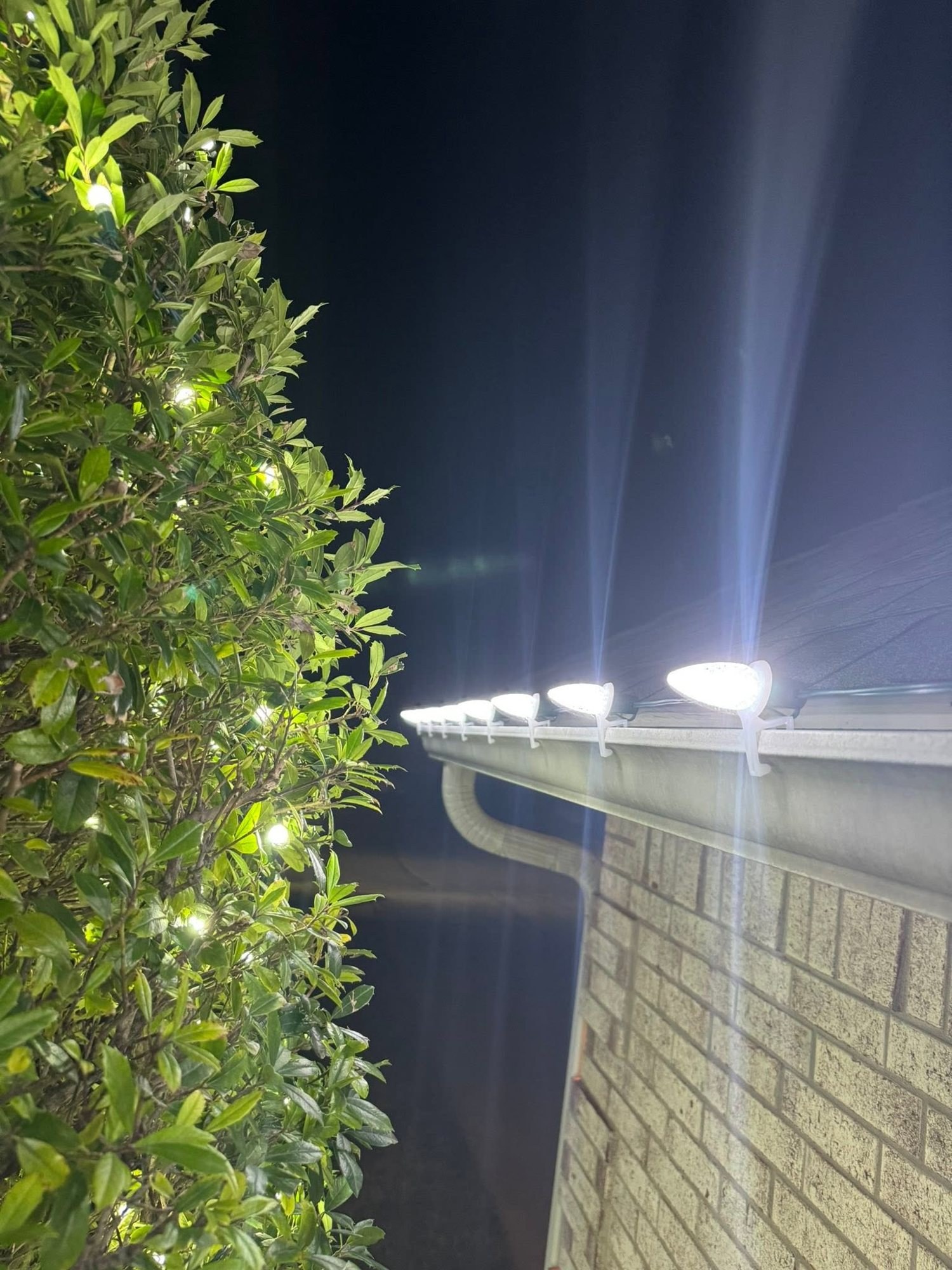 White C9 bulbs along a gutter line at night
